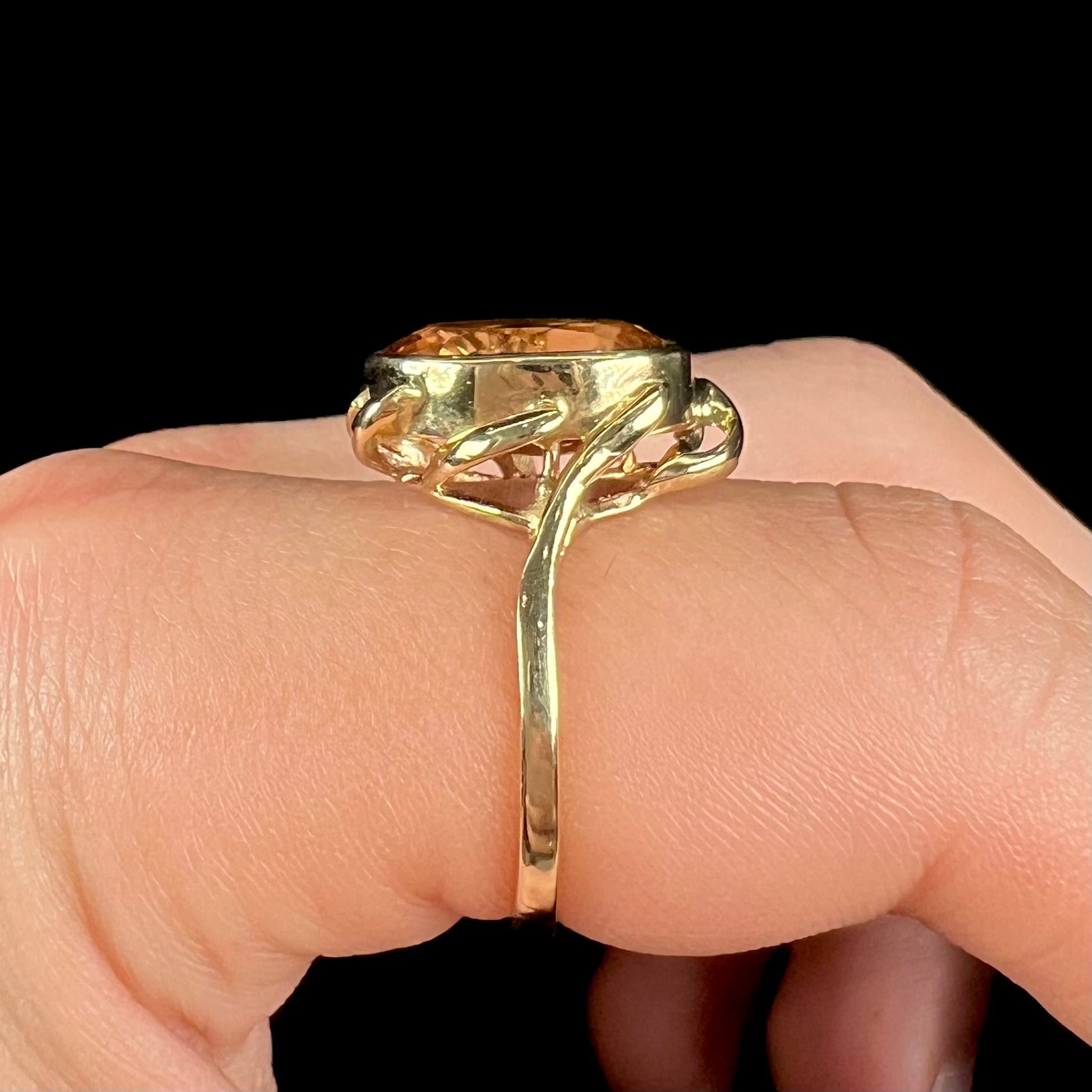 A ladies' yellow gold solitaire ring set with an 8.00 carat oval cut orange hessonite garnet.