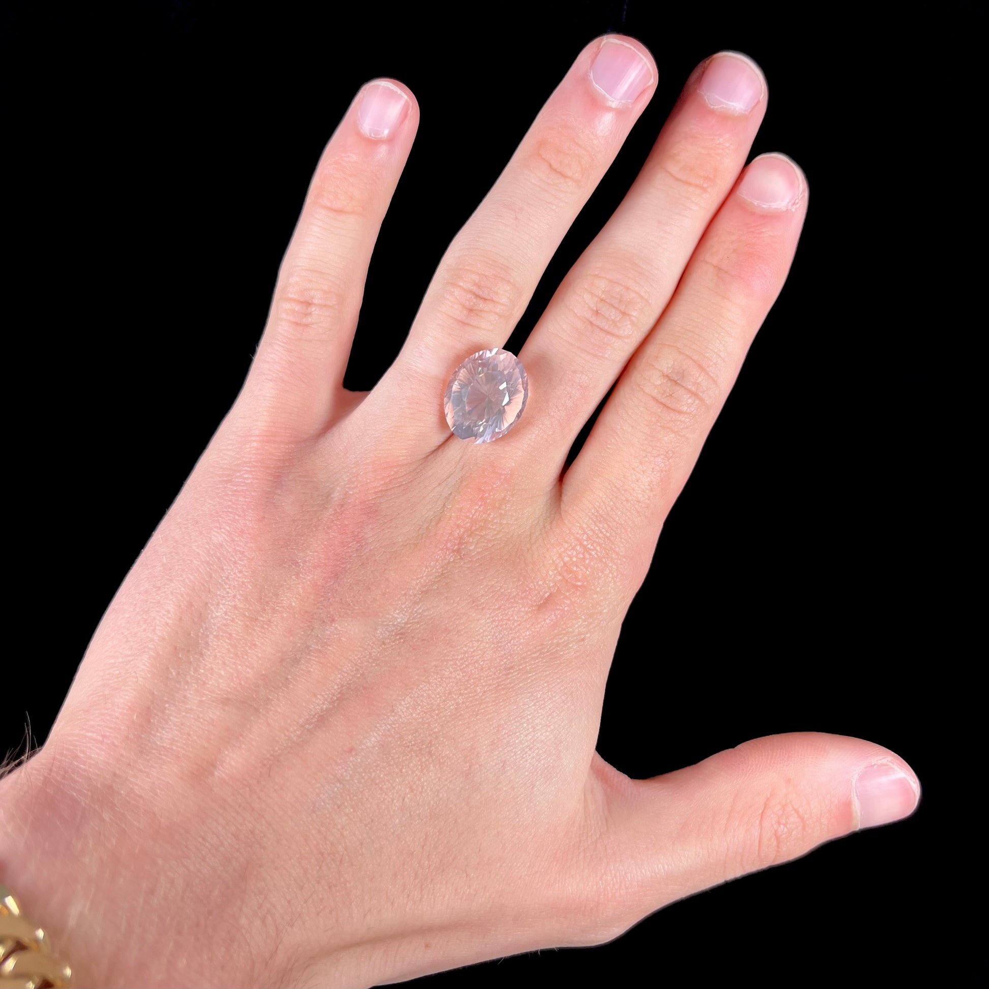A loose, faceted oval cut rose quartz gemstone.  The stone is exceptionally clear.