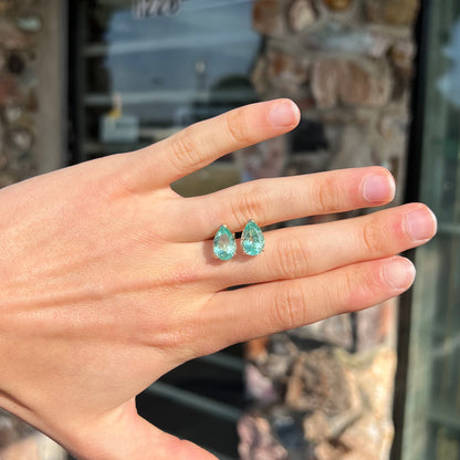 A pair of yellow gold stud earrings set with natural, pear shaped emeralds.