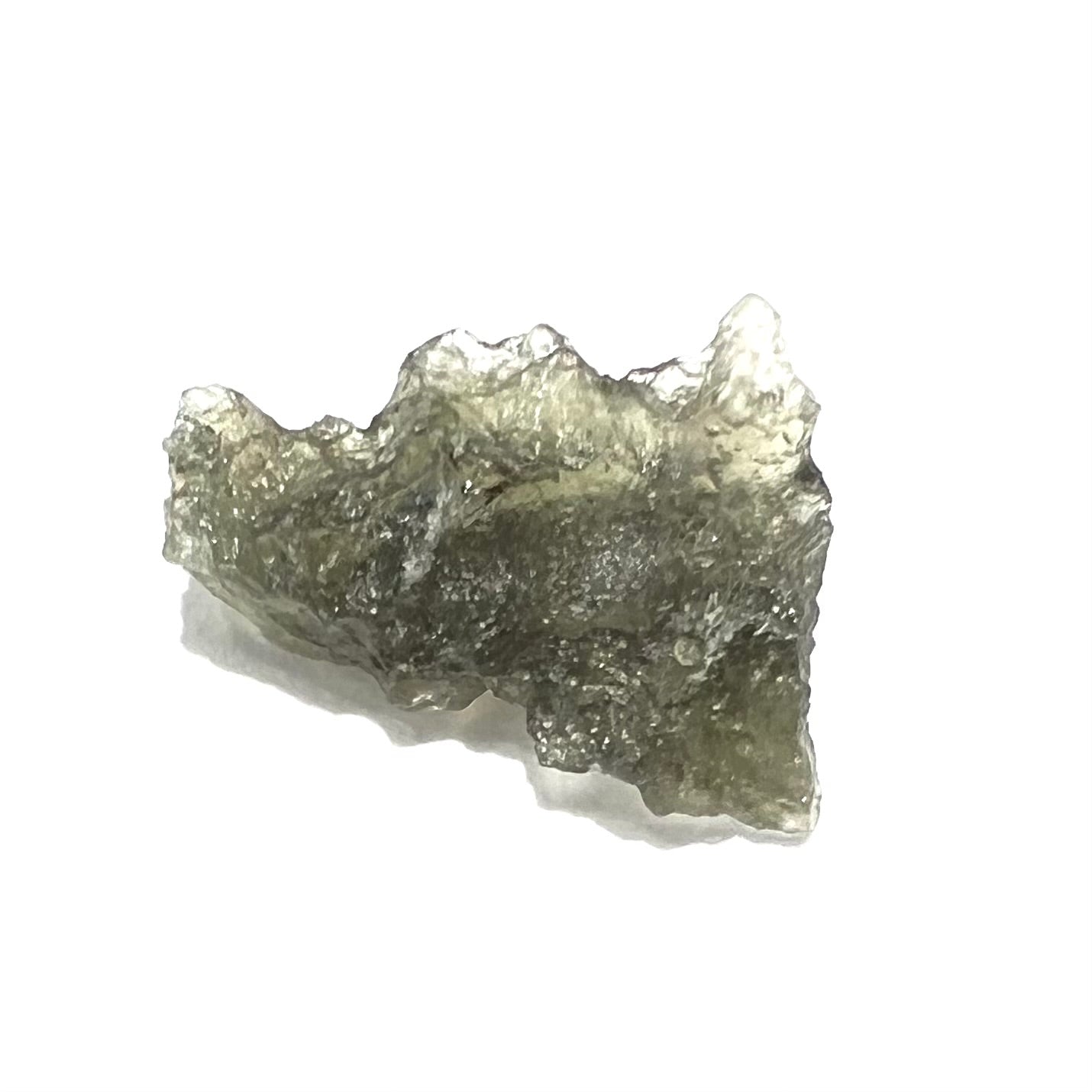 A natural, rough moldavite crystal.  The stone is green color and transluscent.