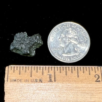 A natural, rough moldavite crystal.  The stone is green color and transluscent.