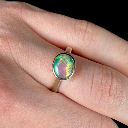 A yellow gold solitaire ring set with a natural Australian cat's eye opal stone.