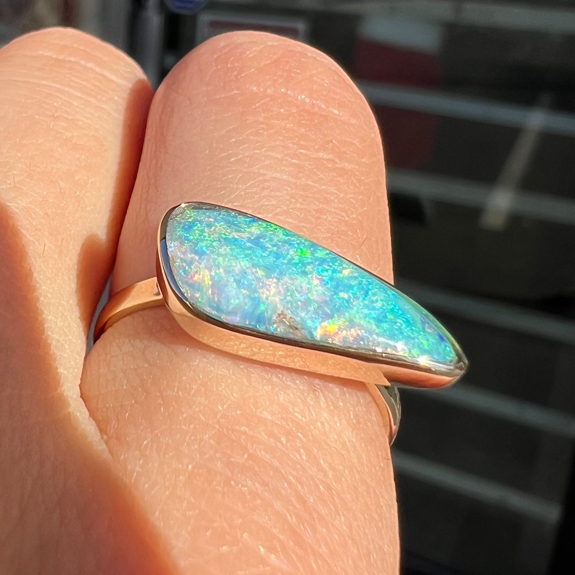 A ladies yellow gold solitaire ring bezel set with a natural opalized seashell from Coober Pedy, Australia.
