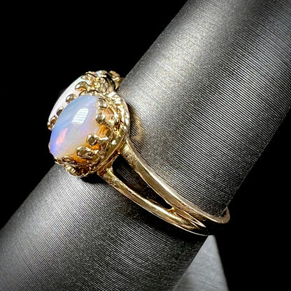A vintage ladies' three stone gold ring set with natural white crystal opals.