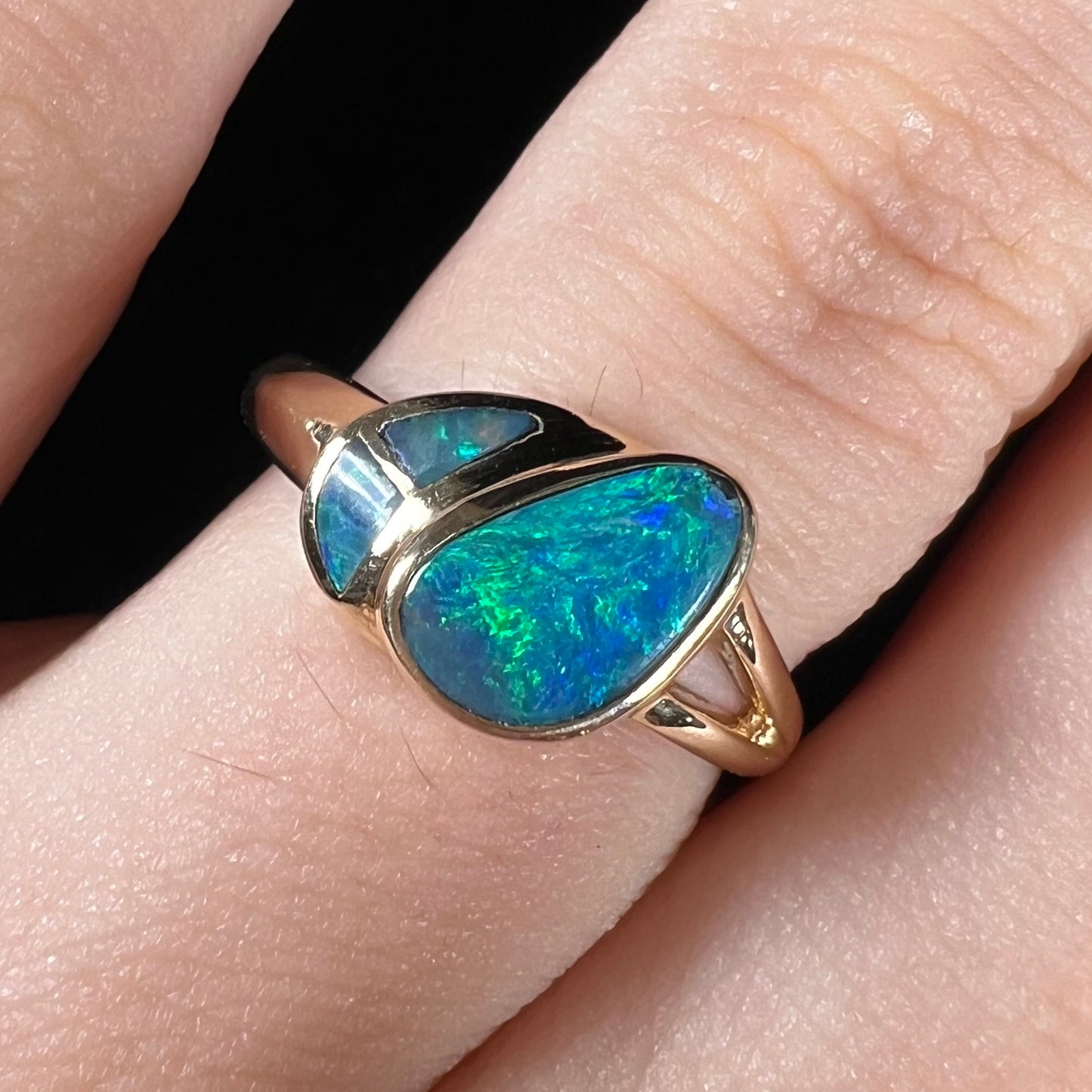 A ladies' black opal inlay ring cast in yellow gold.