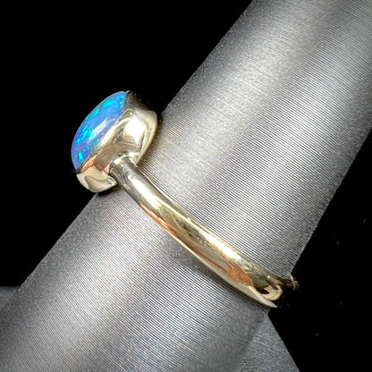 A ladies' natural black crystal opal solitaire ring handmade in 14 karat yellow gold.