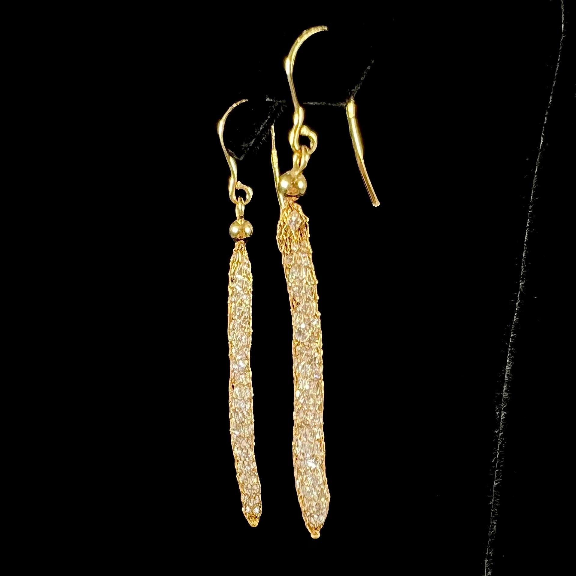 Yellow gold dangle earrings featuring a mesh cage filled with round brilliant cut cubic zirconia stones.