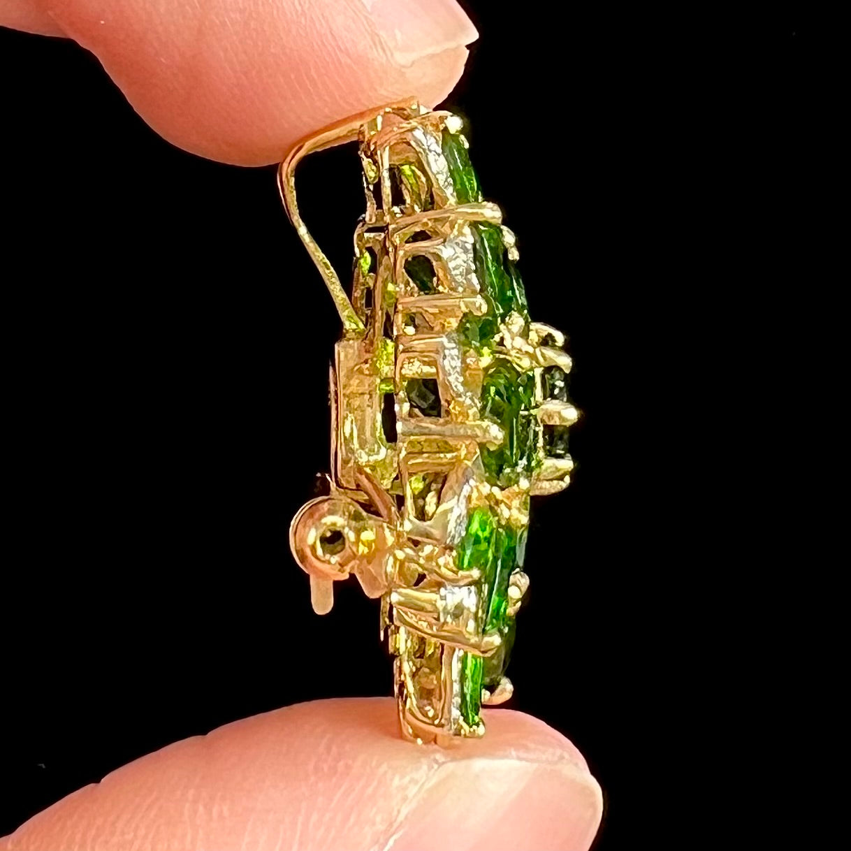 A ladies' pendant set with green chrome diopside stones and diamonds.  The pendant can be worn as a brooch.