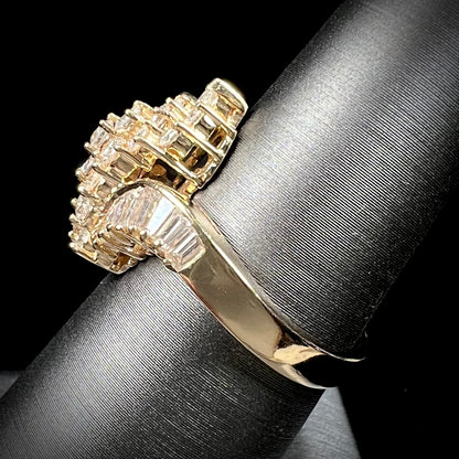 A yellow gold diamond cluster ring set with round, marquise, and baguette cut diamonds.