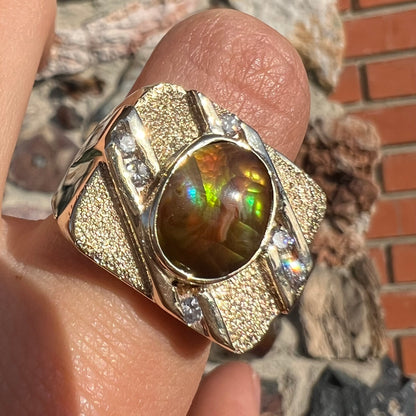 A yellow gold men's ring channel set with diamonds and bezel set with a Mexican fire agate stone.