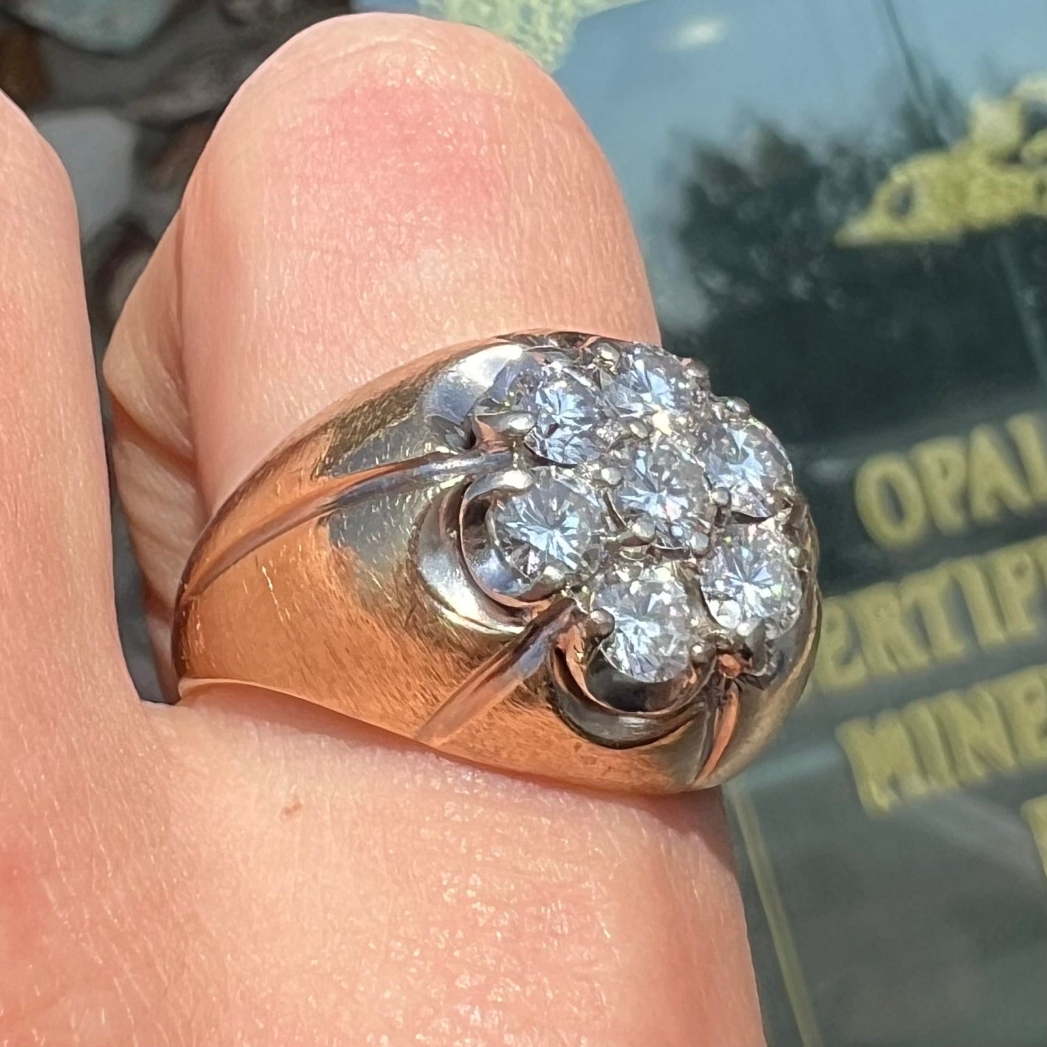 A men's textured yellow gold ring set with a cluster of seven round brilliant cut natural diamonds.