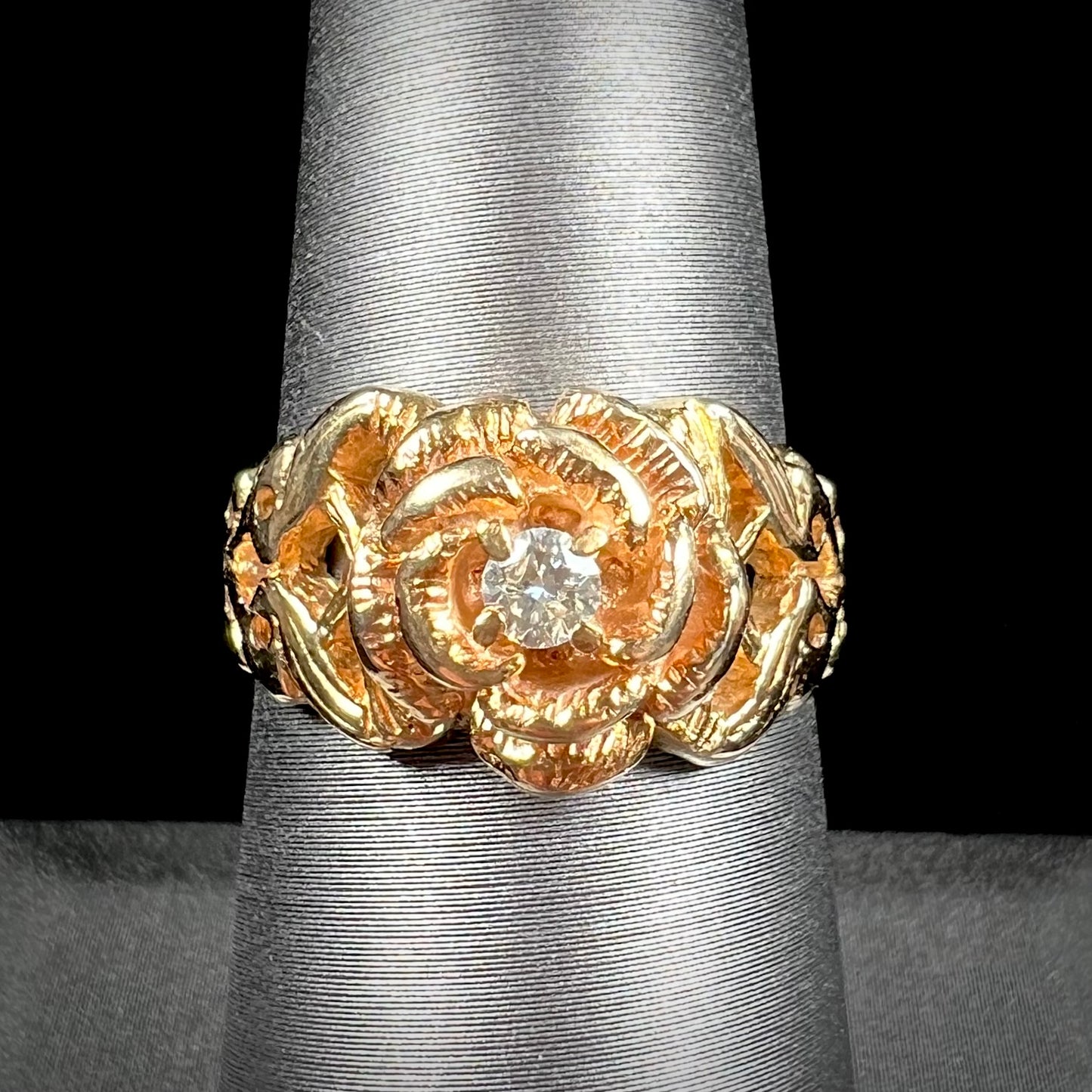 A ladies' yellow gold rose style ring set with a natural 0.10ct diamond.