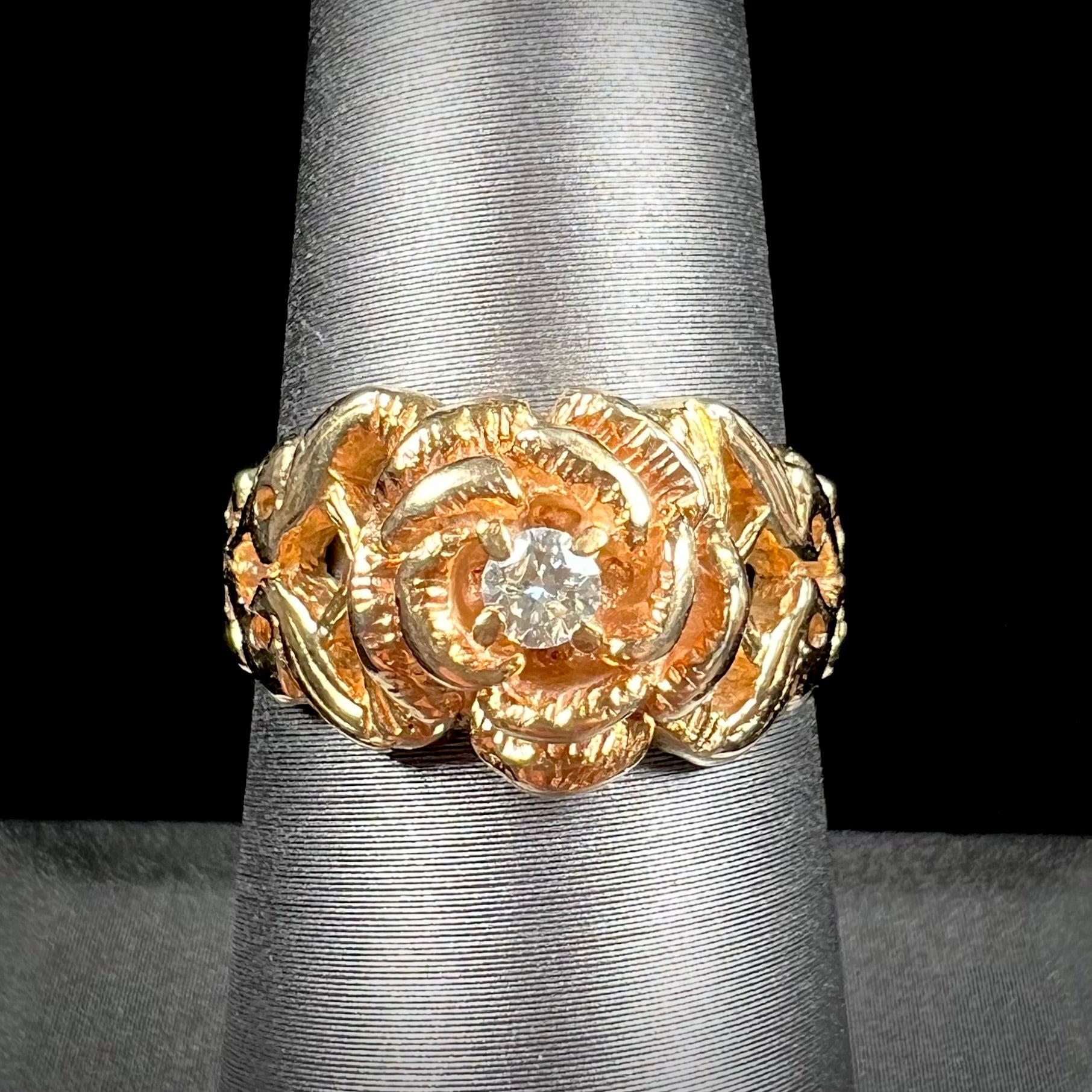 A ladies' yellow gold rose style ring set with a natural 0.10ct diamond.