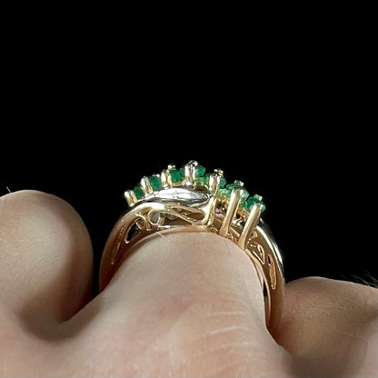 A vintage, 1970's style yellow gold ring set with marquise cut emeralds and round brilliant cut diamonds.