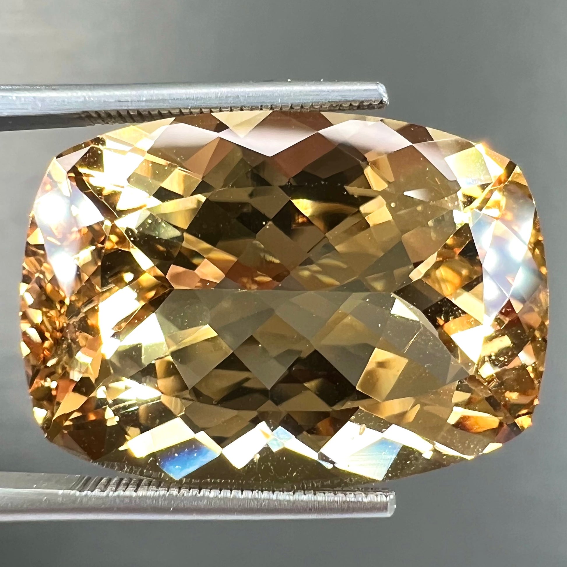 A loose, cushion cut golden beryl stone.