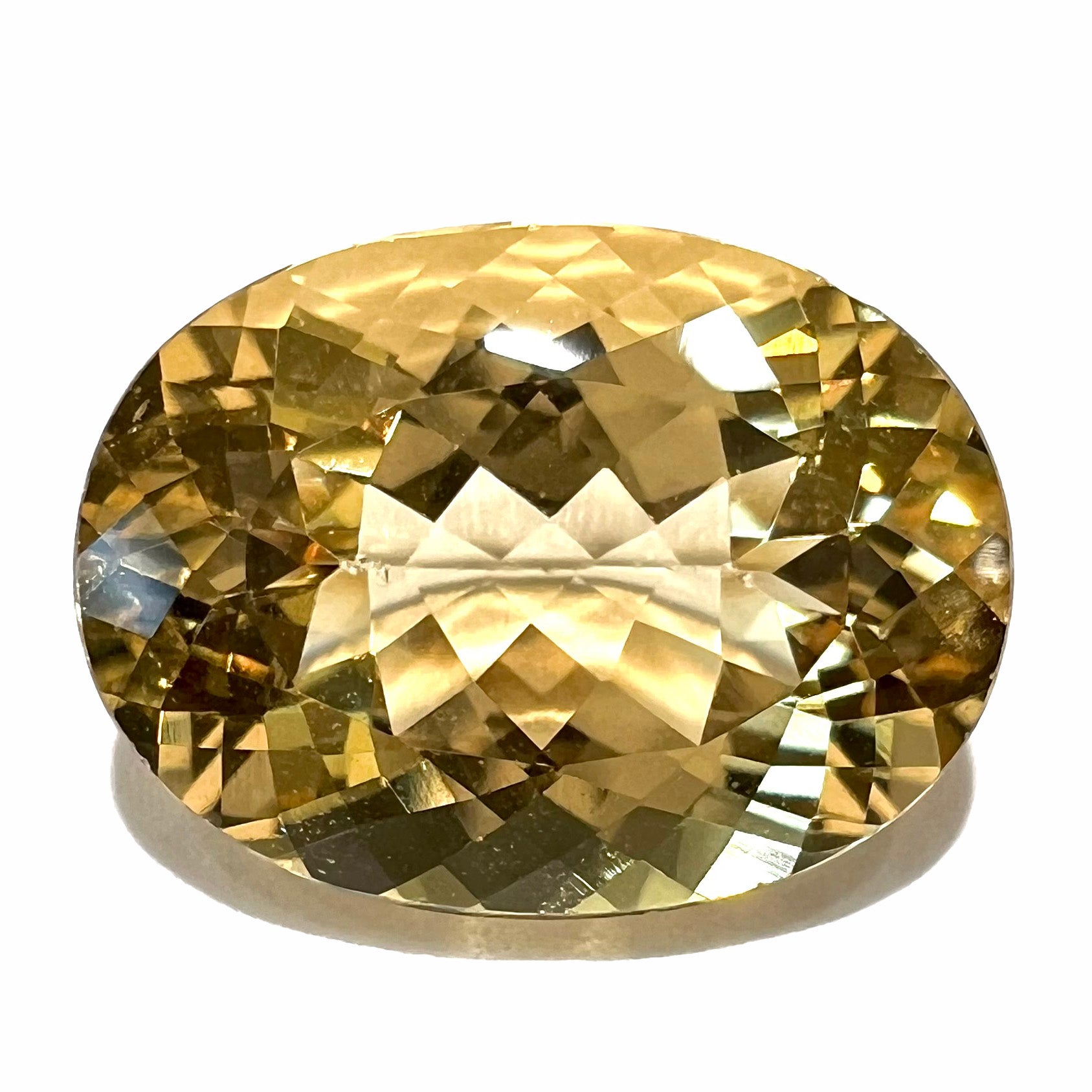 A faceted, oval cut golden beryl gemstone.