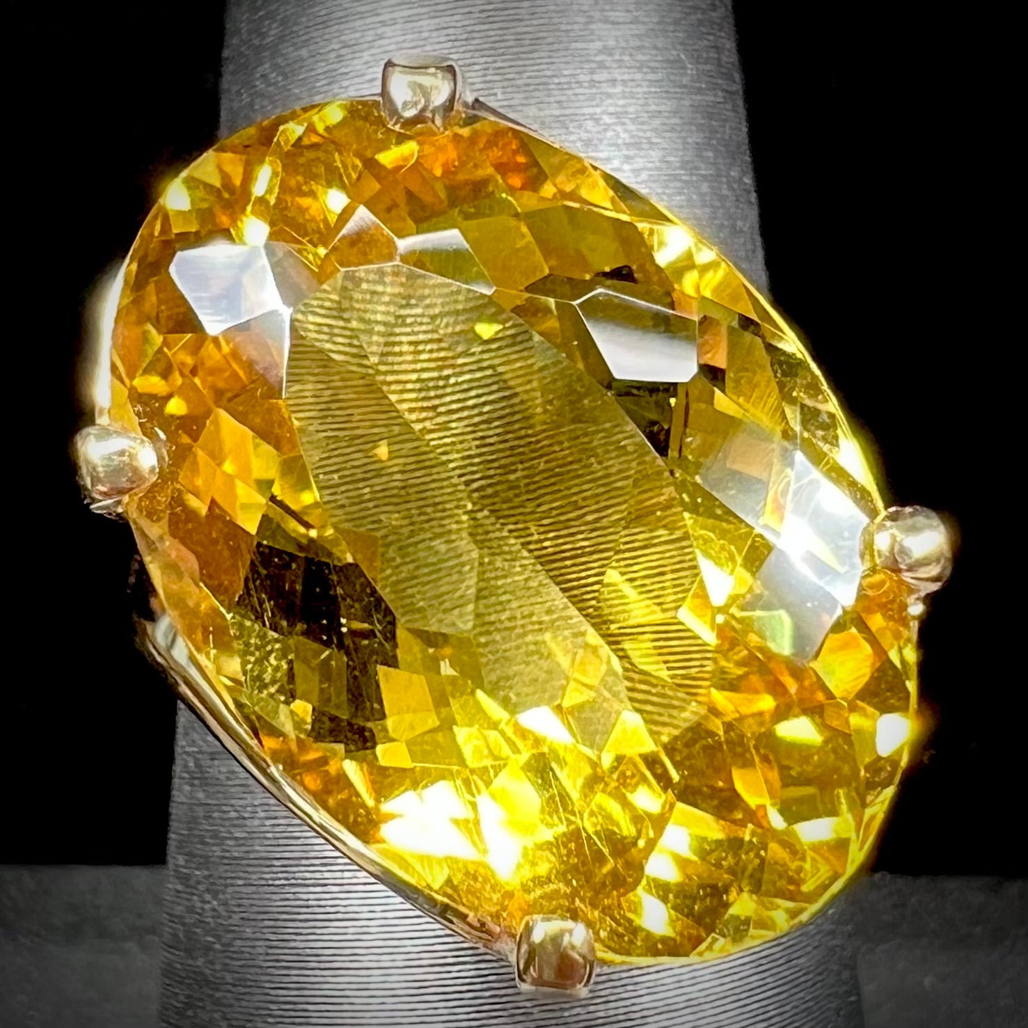 An 18 karat yellow gold solitaire cocktail ring set with a faceted oval cut golden beryl gemstone.