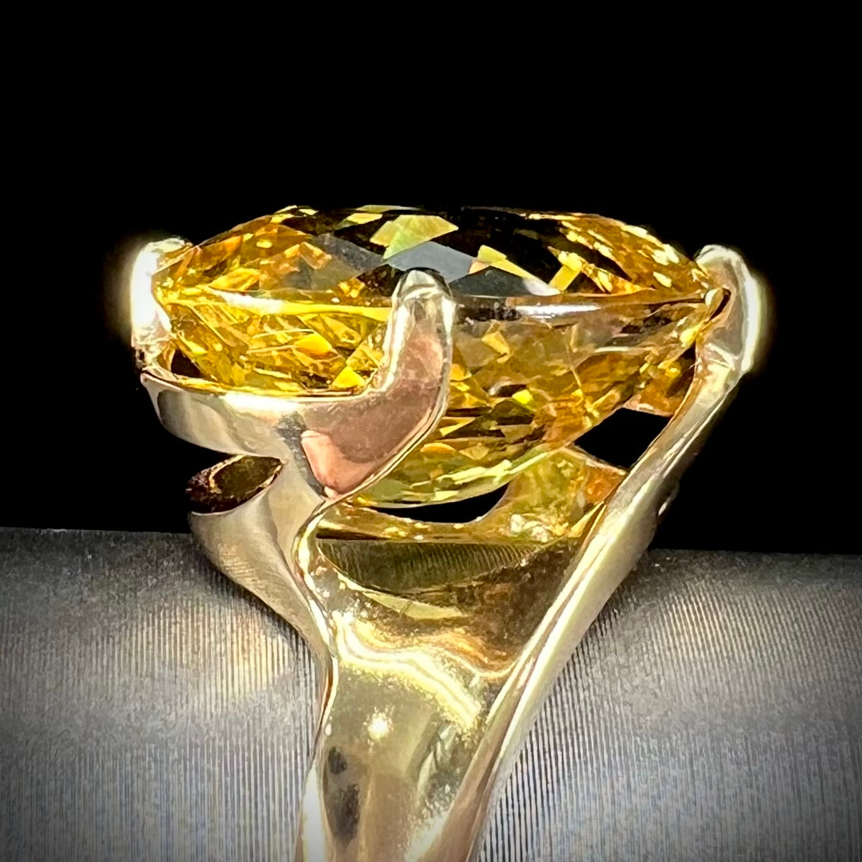 An 18 karat yellow gold solitaire cocktail ring set with a faceted oval cut golden beryl gemstone.