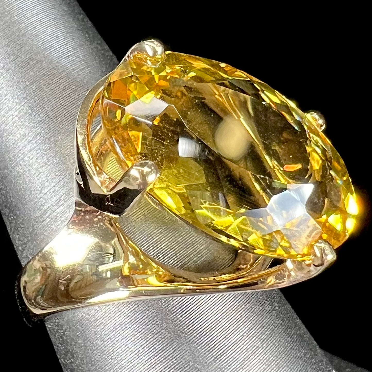 An 18 karat yellow gold solitaire cocktail ring set with a faceted oval cut golden beryl gemstone.