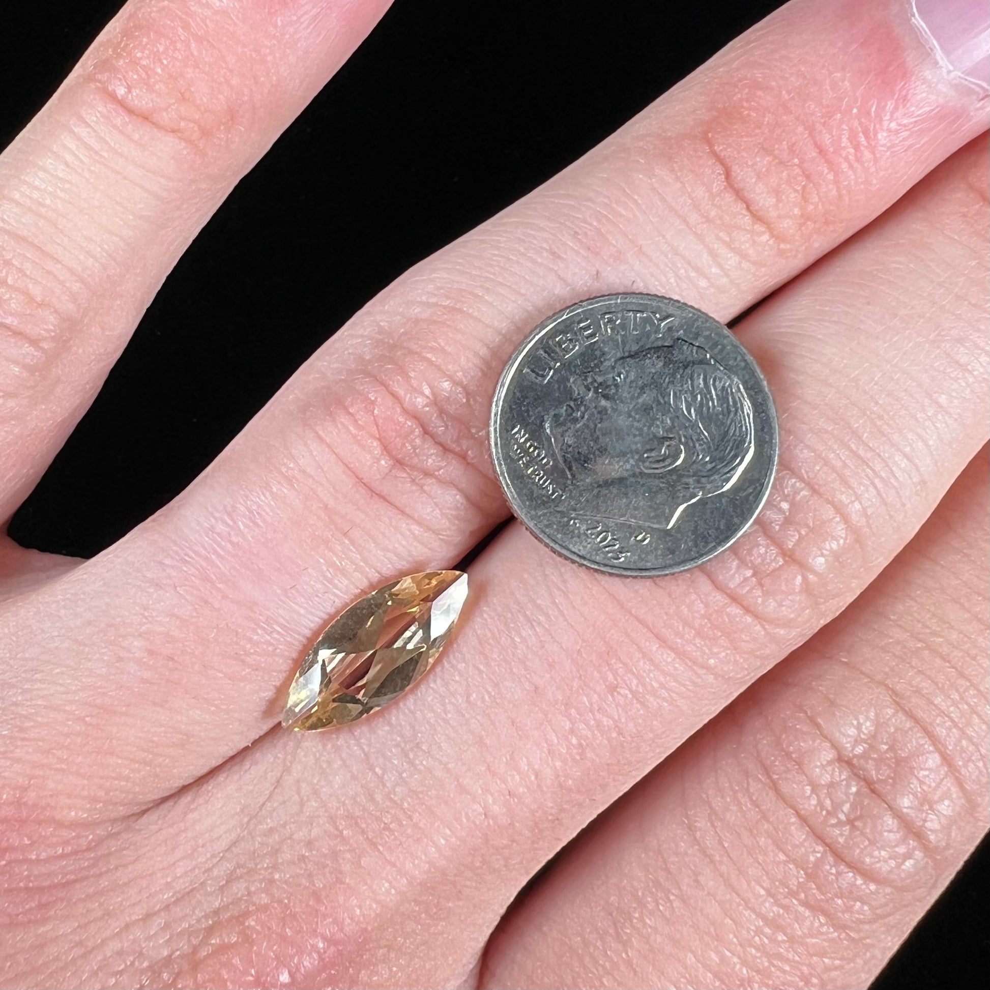 A loose, marquise cut golden beryl gemstone.  The stone is a light yellow color.