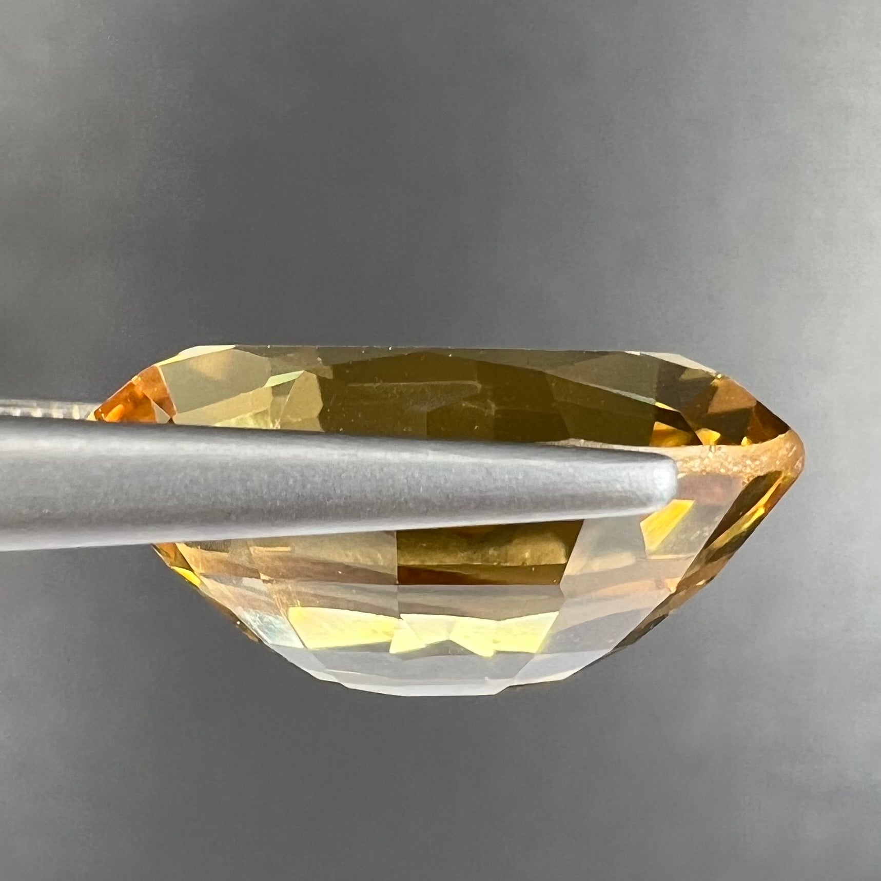A loose, faceted oval cut golden beryl gemstone.