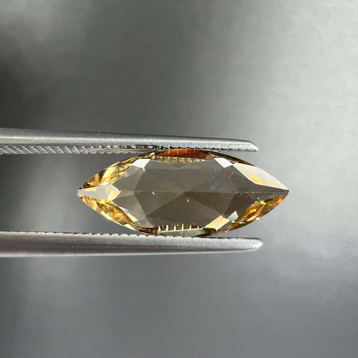 A loose, marquise cut golden beryl gemstone.  The stone is a light yellow color.