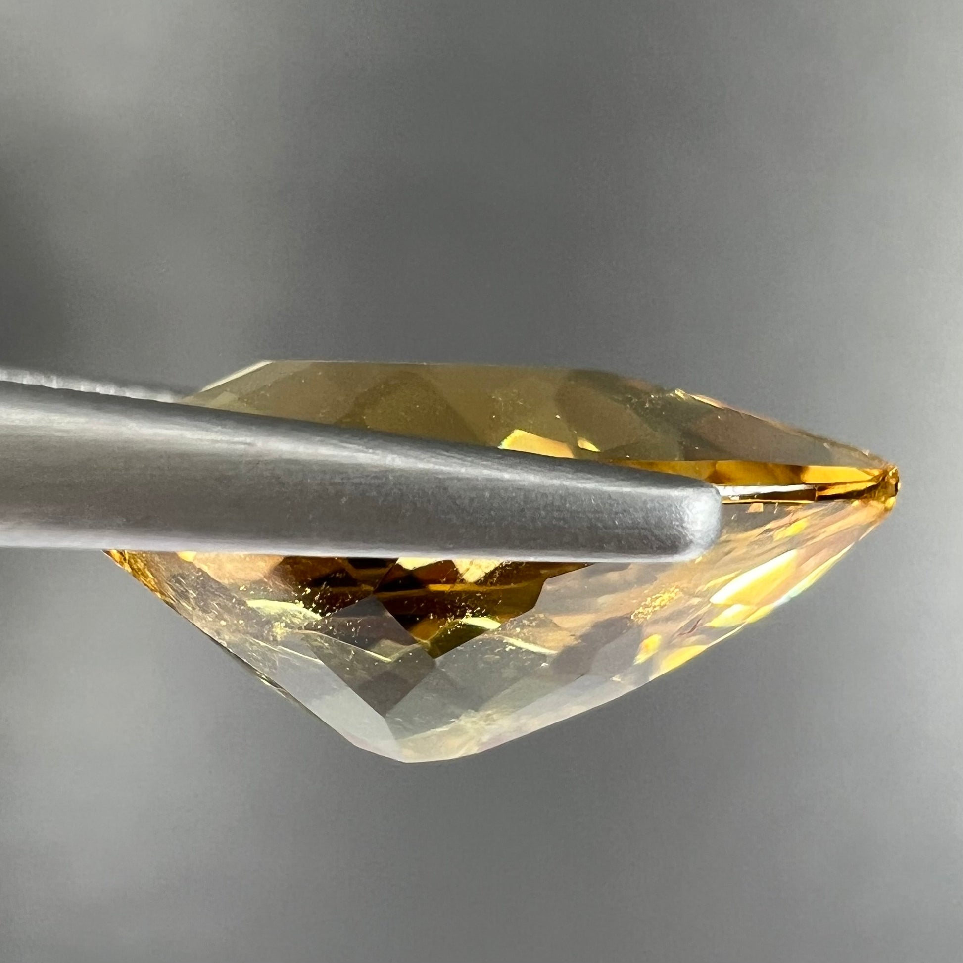 A loose, pear shaped golden beryl gemstone.