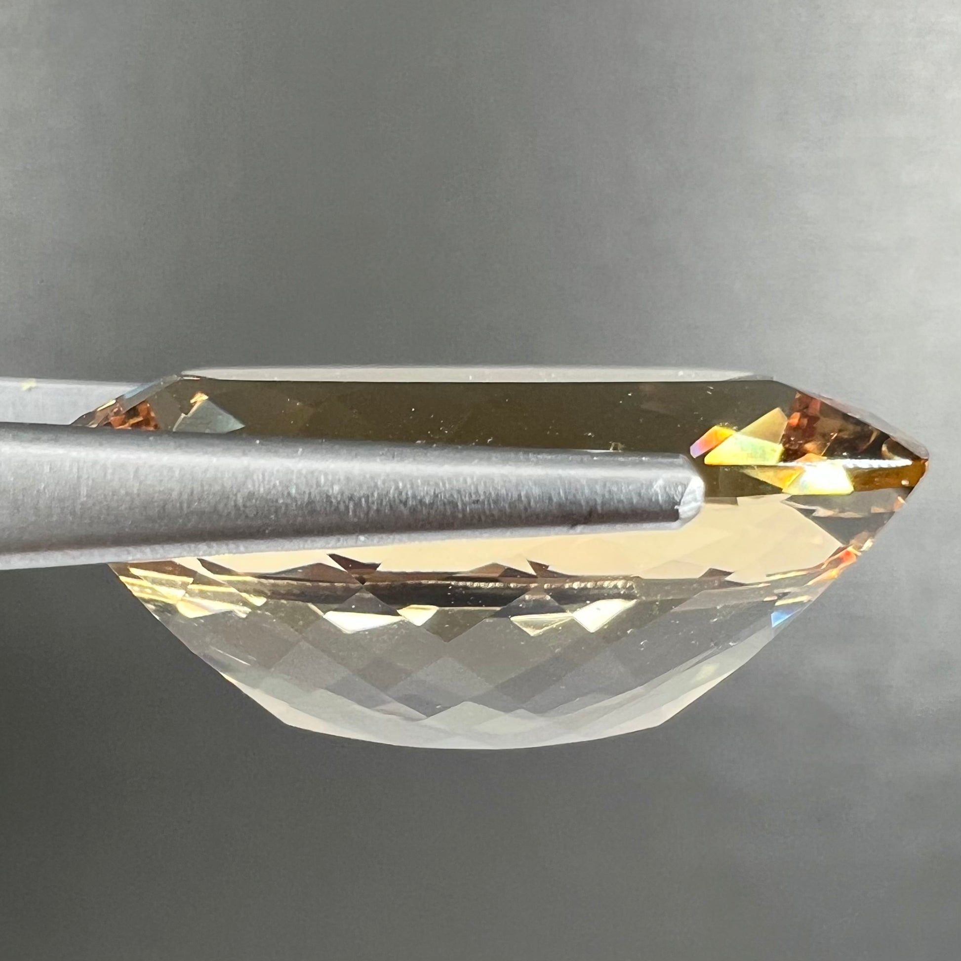 A loose, cushion cut golden beryl stone.
