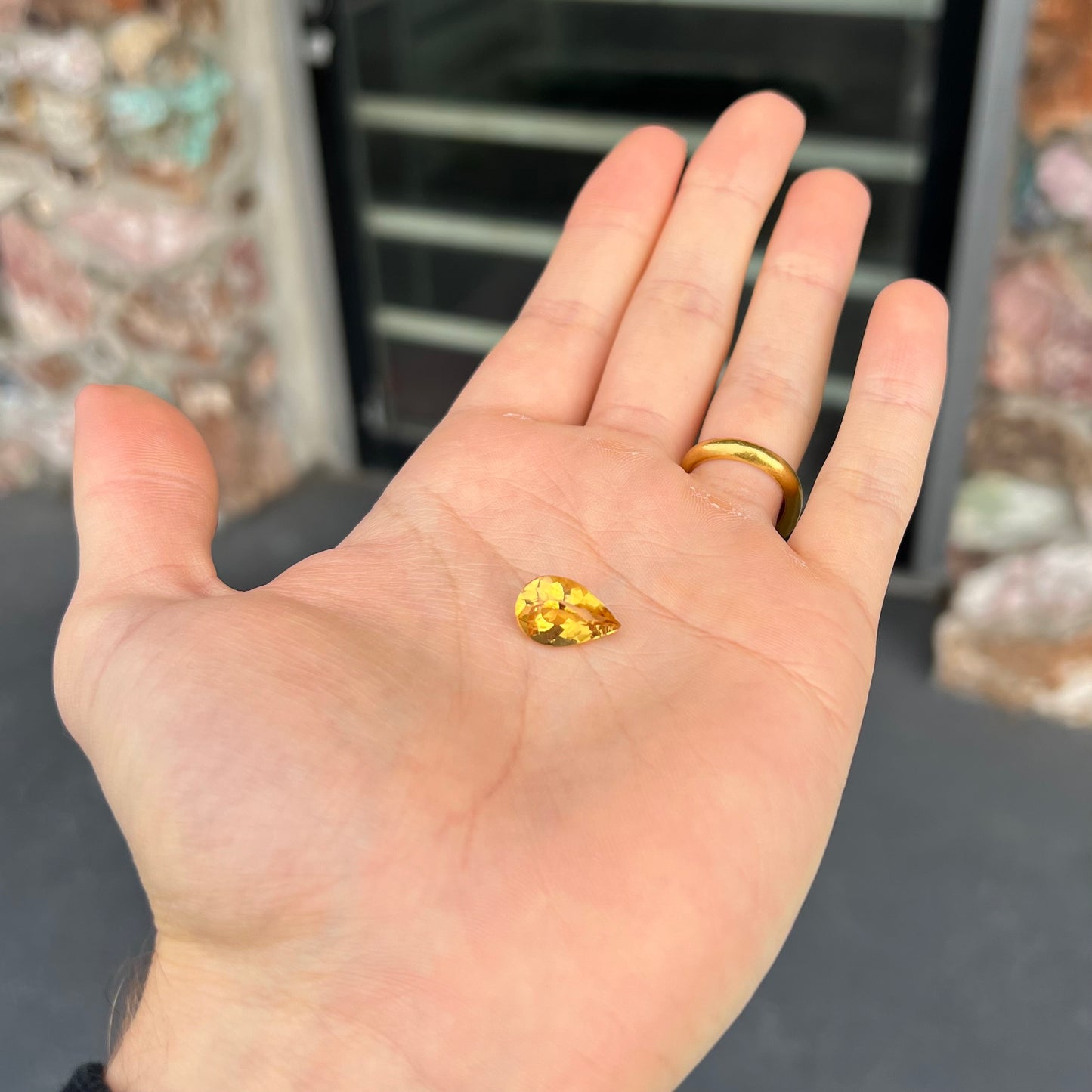 A loose, pear shaped golden beryl gemstone.