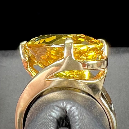 An 18 karat yellow gold solitaire cocktail ring set with a faceted oval cut golden beryl gemstone.