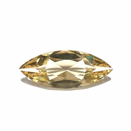 A loose, marquise cut golden beryl gemstone.  The stone is a light yellow color.