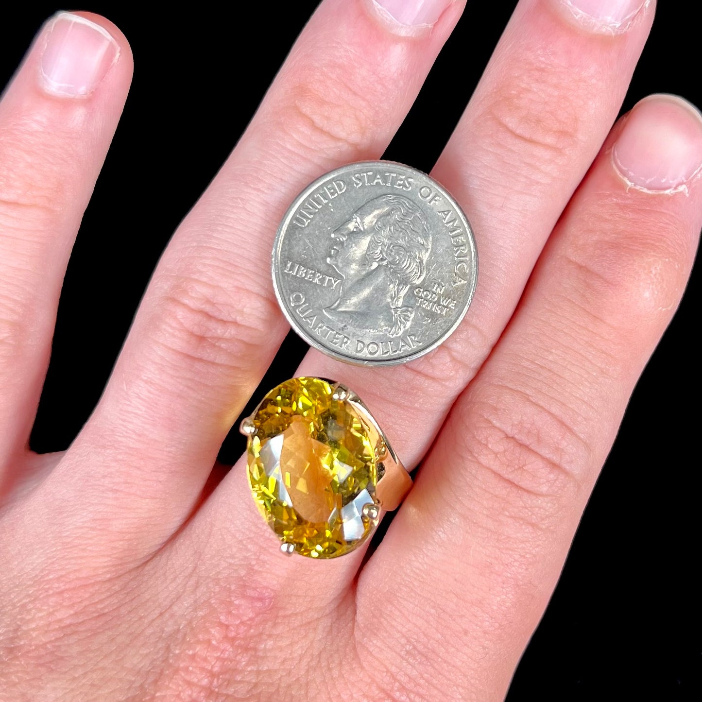An 18 karat yellow gold solitaire cocktail ring set with a faceted oval cut golden beryl gemstone.