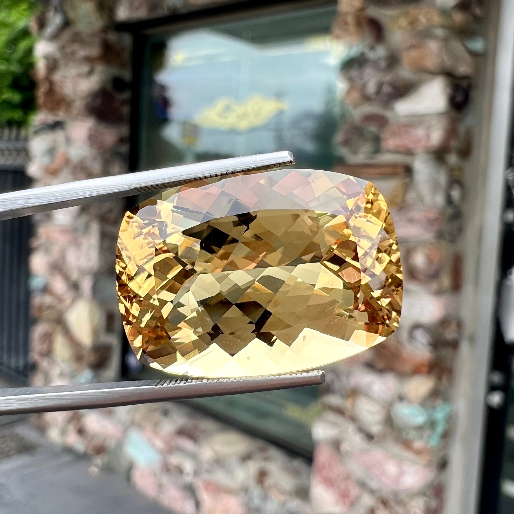 A loose, cushion cut golden beryl stone.