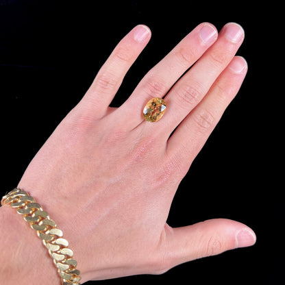 A faceted, oval cut golden beryl gemstone.