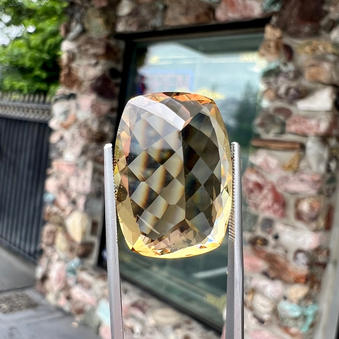 A loose, cushion cut golden beryl stone.