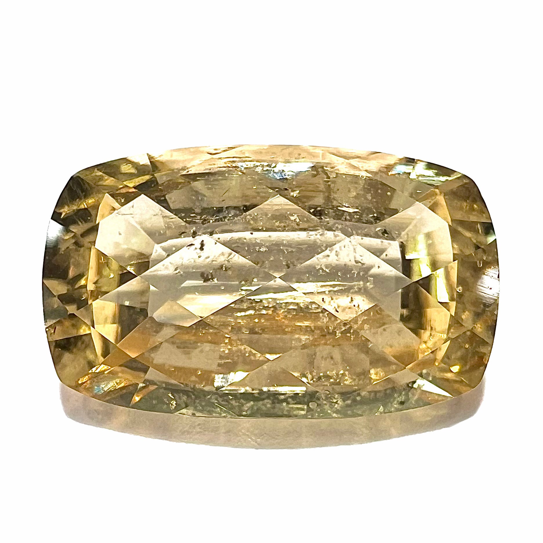 A loose, checkerboard cushion cut golden topaz gemstone.  The stone is a yellow color.