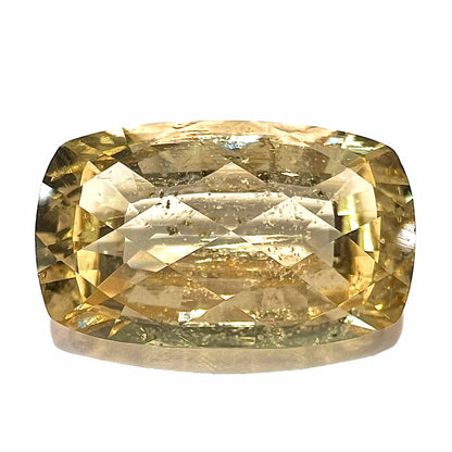 A loose, checkerboard cushion cut golden topaz gemstone.  The stone is a yellow color.