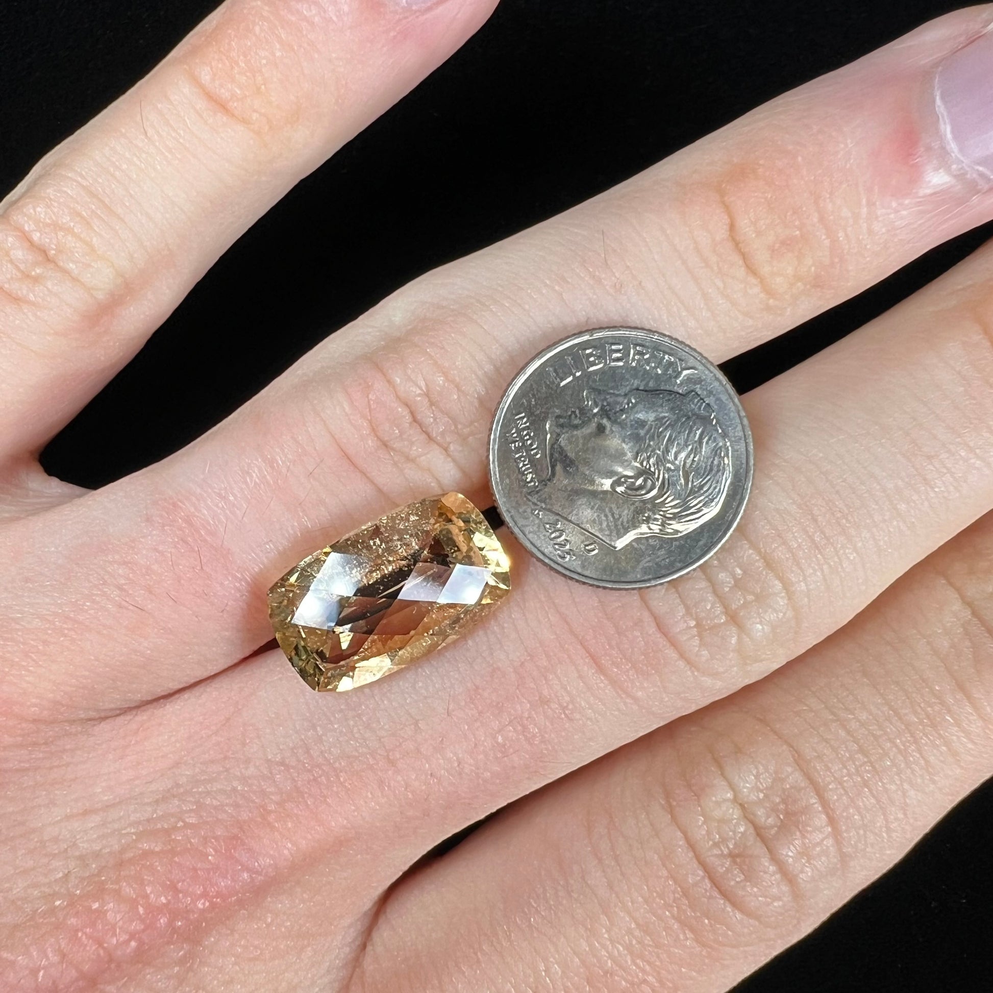 A loose, checkerboard cushion cut golden topaz gemstone.  The stone is a yellow color.