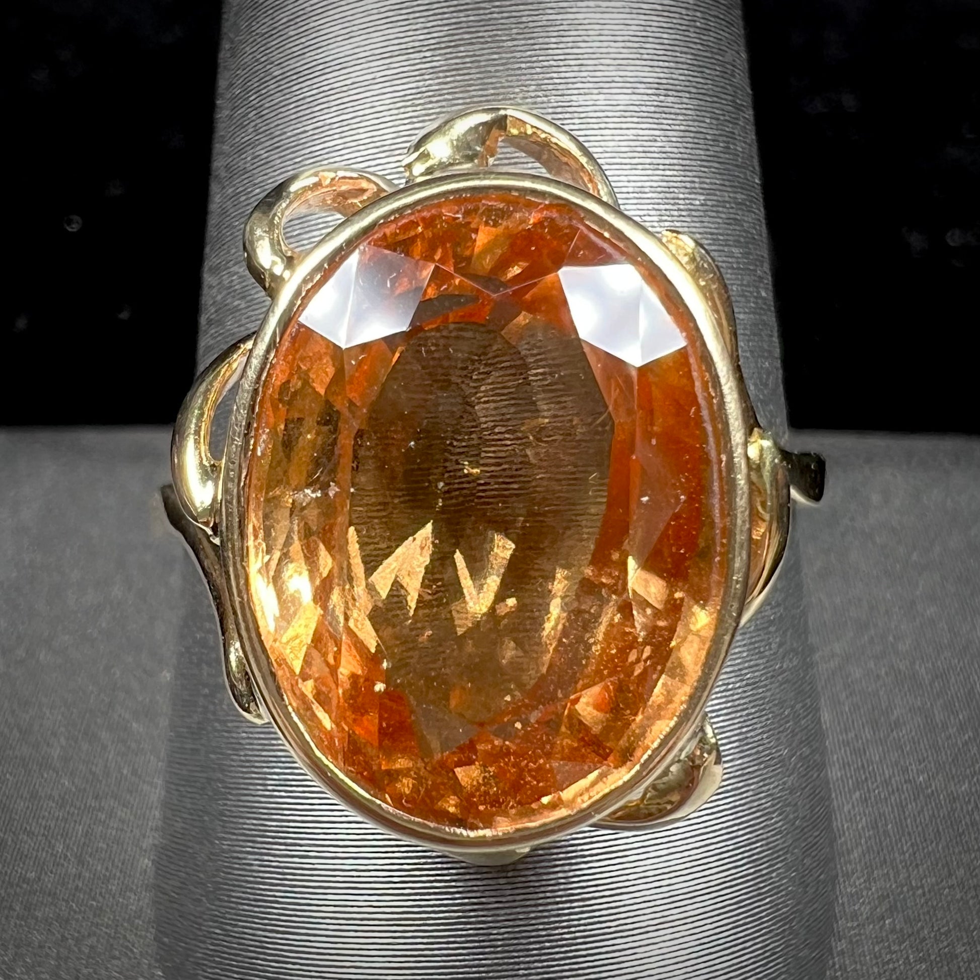 A ladies' yellow gold solitaire ring set with an 8.00 carat oval cut orange hessonite garnet.