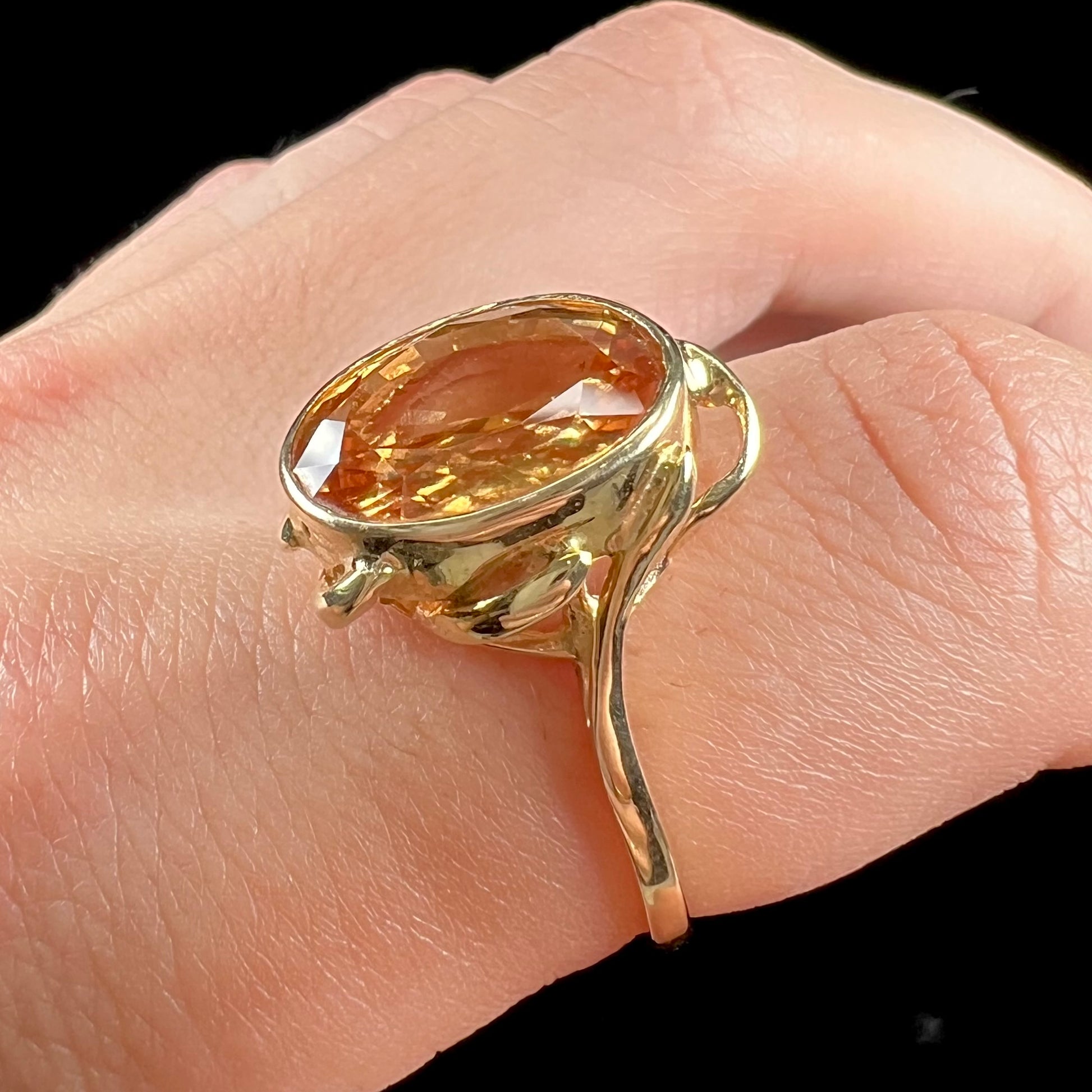 A ladies' yellow gold solitaire ring set with an 8.00 carat oval cut orange hessonite garnet.