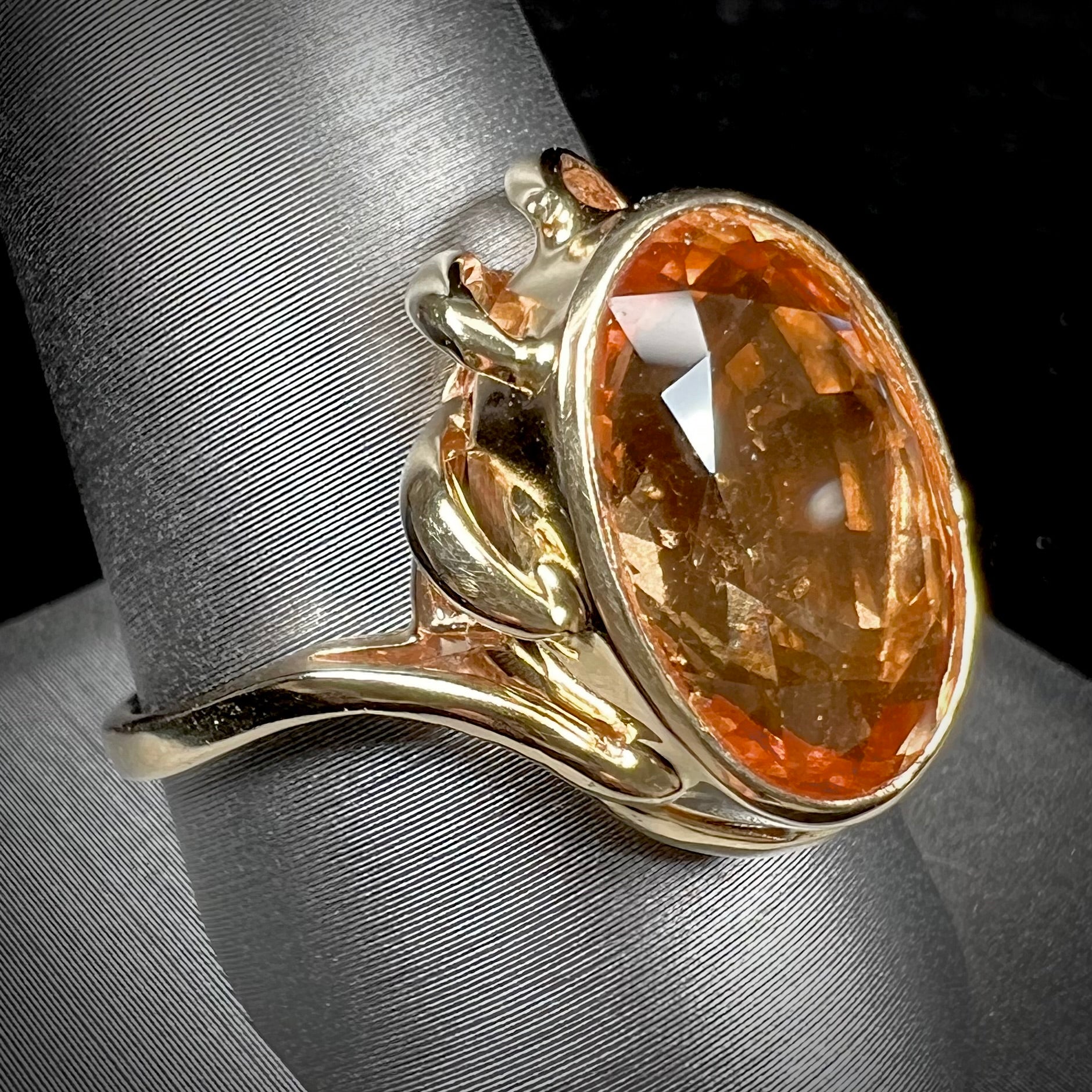 A ladies' yellow gold solitaire ring set with an 8.00 carat oval cut orange hessonite garnet.