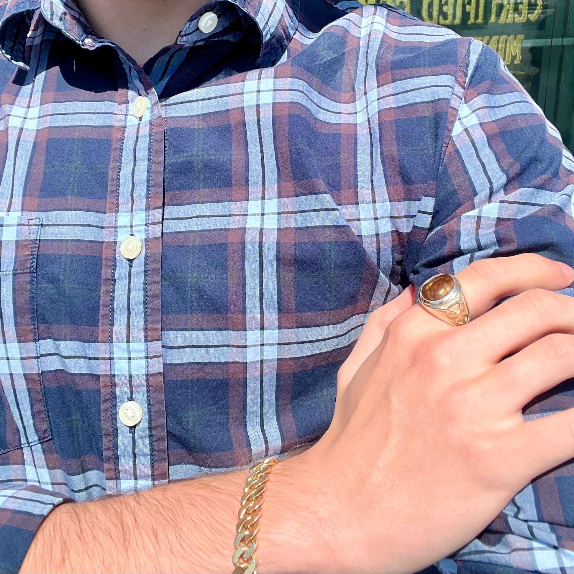 A men's solid yellow gold ring set with a Mexican fire agate stone.  The fire agate has a puple bull's eye pattern.
