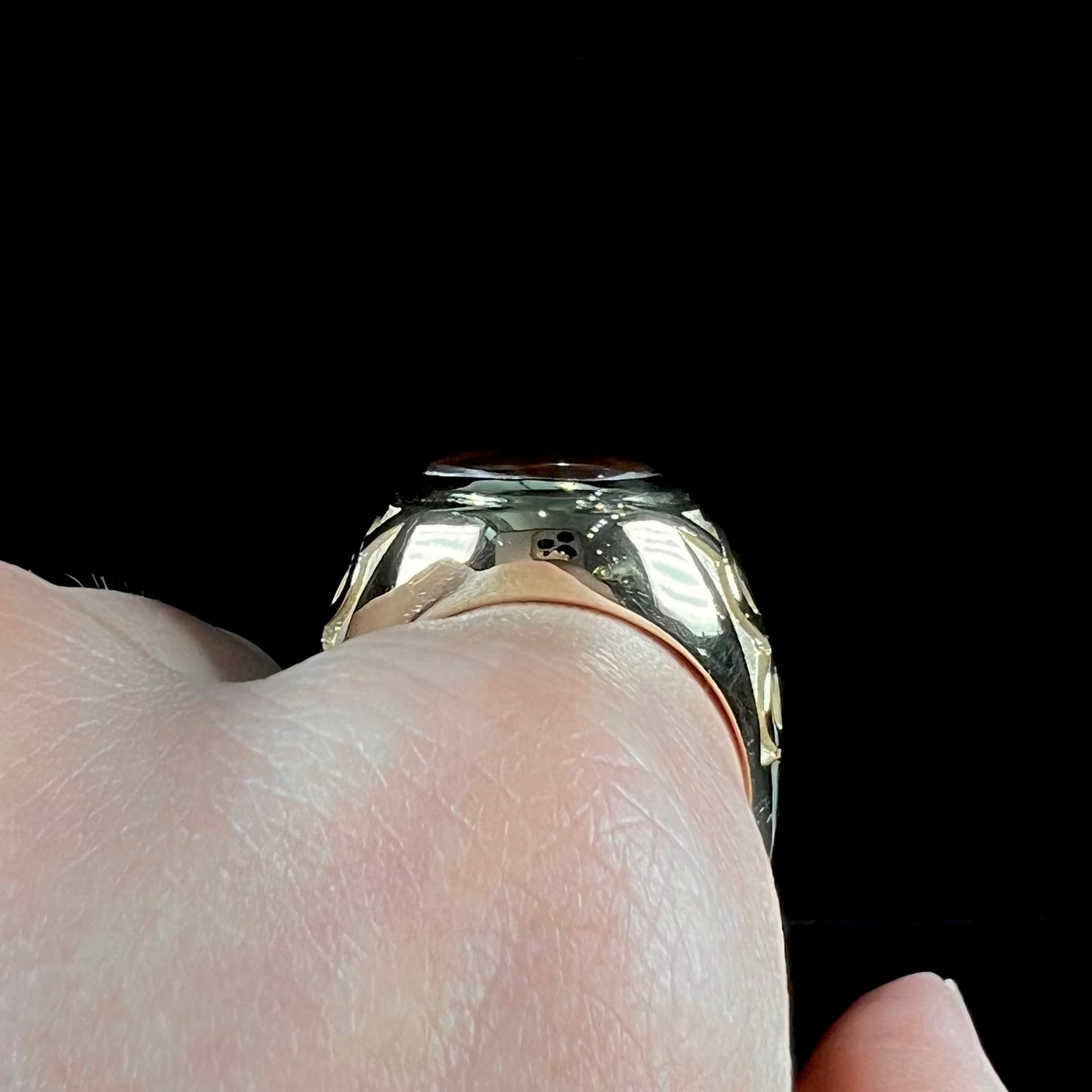 A men's solid yellow gold ring set with a Mexican fire agate stone.  The fire agate has a puple bull's eye pattern.