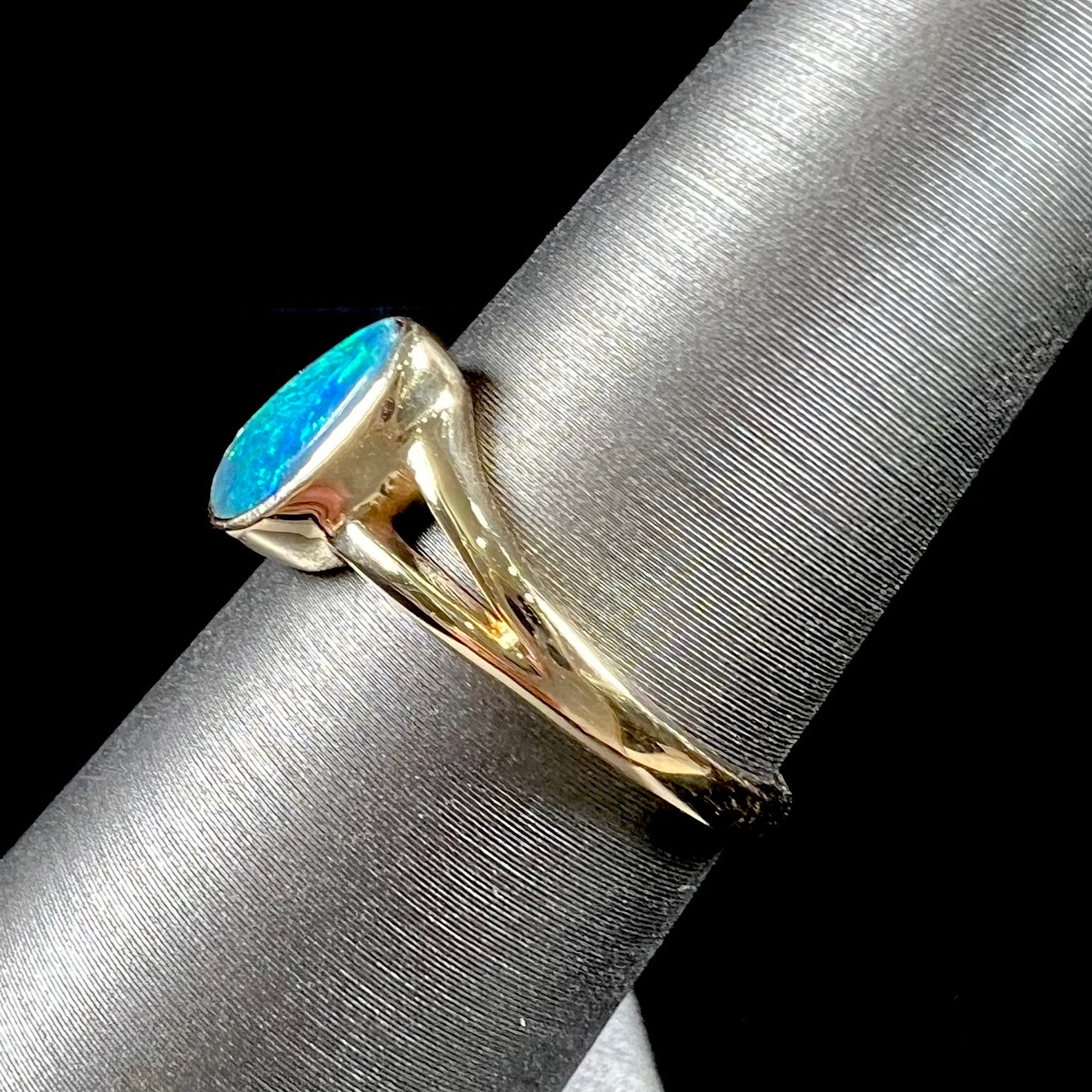 A ladies' black opal inlay ring cast in yellow gold.