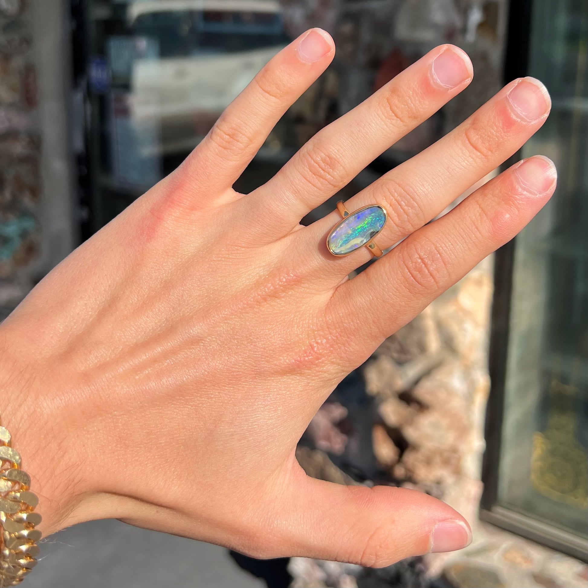 Ladies' yellow gold solitaire ring bezel set with a natural green striped boulder opal from Quilpie, Australia.