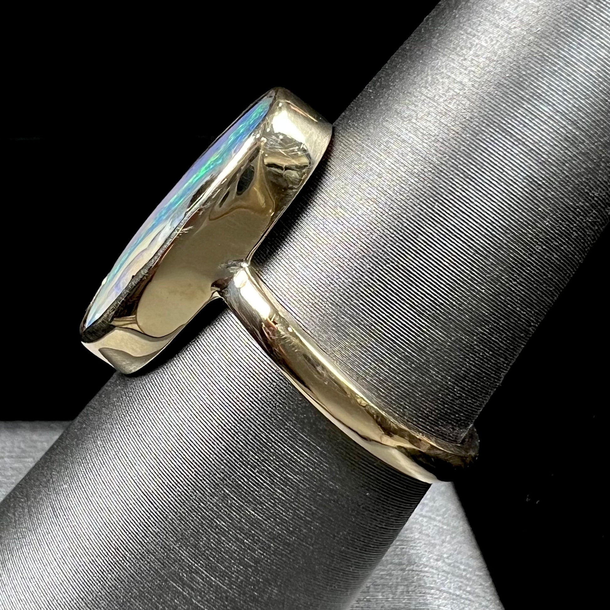 Ladies' yellow gold solitaire ring bezel set with a natural green striped boulder opal from Quilpie, Australia.