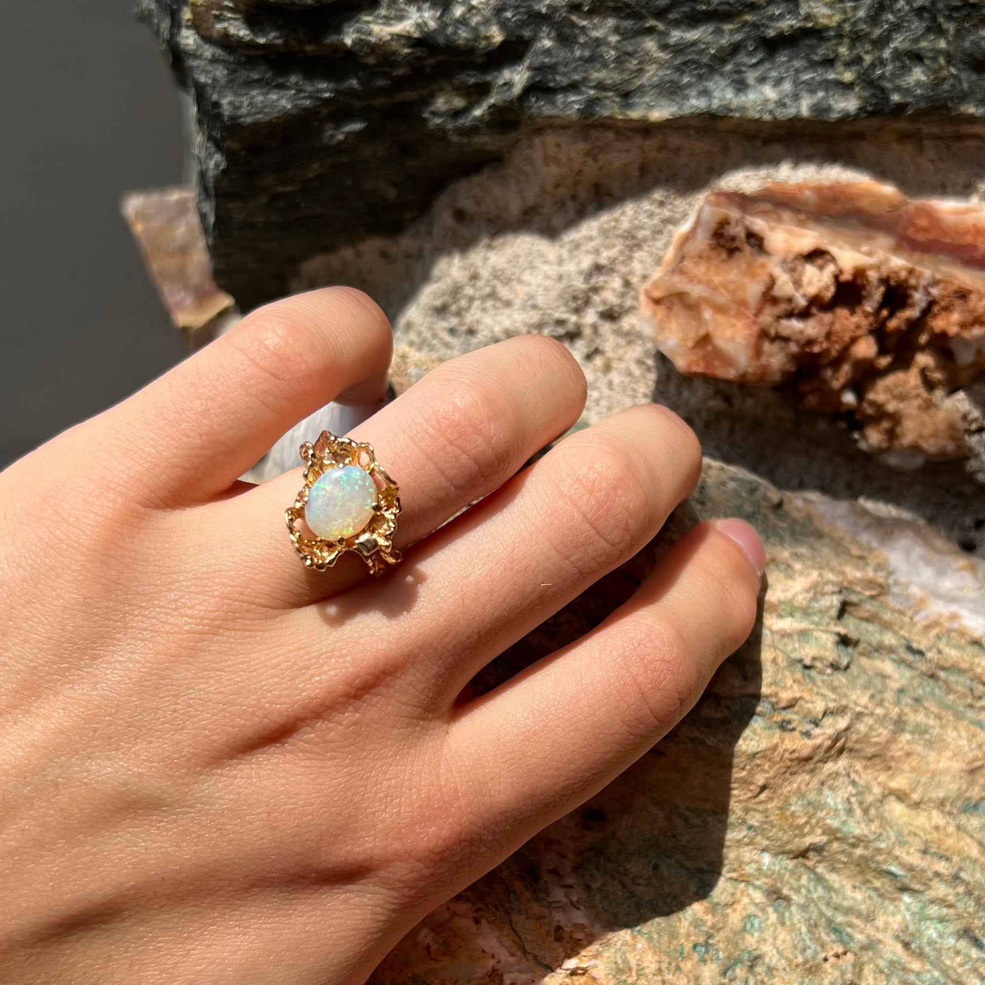 A ladies' organic style yellow gold ring prong set with a natural, green Australian crystal opal.