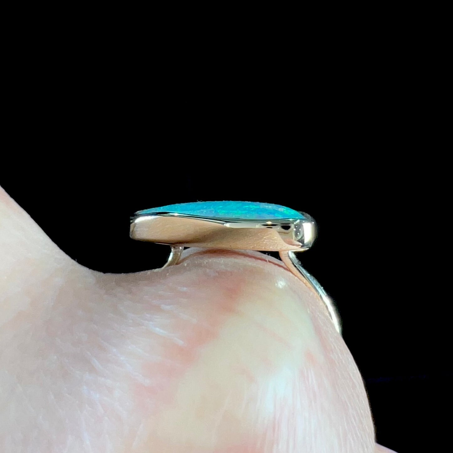 A ladies yellow gold solitaire ring bezel set with a natural opalized seashell from Coober Pedy, Australia.