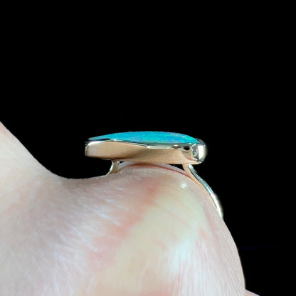 A ladies yellow gold solitaire ring bezel set with a natural opalized seashell from Coober Pedy, Australia.