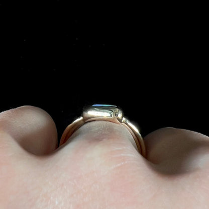 A ladies' split shank gold ring bezel set with a natural, Australian black boulder opal.